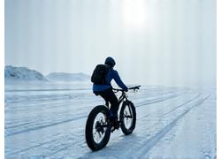 Cyclist braving snowy, remote arctic landscape with specialized fat bike